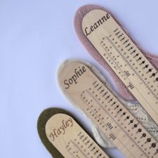 Personalized wooden sock rulers with needle gauge.
