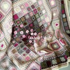 Variations on granny squares throughout, with a sprinkling of attached cherry blossoms across the middle of the blanket.