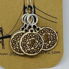 Wood disk shaped stitch markers with Cthulhu, whose tentacles form Celtic knots.