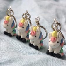 Row of four tiny unicorns with multicolor manes.