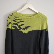 Colorwork sweater with bat silhouettes across one shoulder and one side of the yoke.