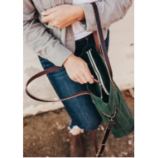 Top view into waxed canvas bag with two sections, divided by zipper pocket. Bag has two leather handles and a leather shoulder strap.