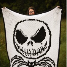 Black on white blanket of Jack Skellington’s head with a bat beneath.