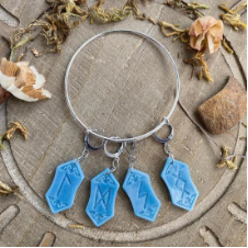 Wire bracelet with four resin rune stitch markers/progress keepers attached.