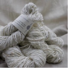 Undyed single ply yarn with a silky sheen.