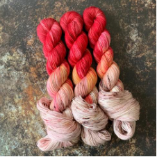 Variegated yarns that go from nearly white to fire engine red.