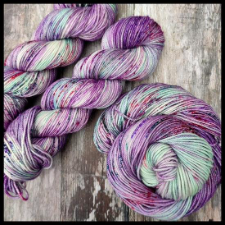 Variegated yarns in cool berry shaded midtones.