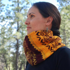 Wide cowl with geometric colorwork in three warm colors.