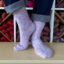 Socks with a cable down the top of the foot, and a lattice pattern across the back.