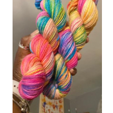 Variegated yarn in a number of bright colors, photographed in the dyer’s hand.