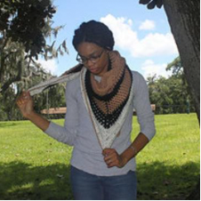 Crocheted triangular shawl in chevron shaped stripes.