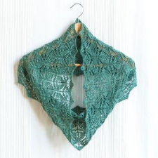 Medium length lace cowl blocked to points at the edges. The knitted-lace stitch patterns echo each other and form staggered diamonds and shallow chevrons.