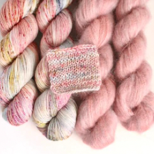 Strawberries and cream variegated skeins with coordinating mohair semisolid pink. Knitted sample shows subtle striping.