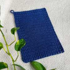 rectangular crocheted tea towel with hanging loop in one corner.
