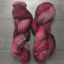 Variegated yarn in light to medium red wine shades.