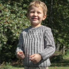 Pre-schooler in long-sleeve pullover with diamond texture at the yoke and ribs down the body and sleeves.