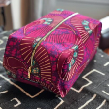Shoebox-shaped zipper pouch with brightly colored curving designs and Batik details.