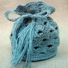 Crocheted drawstring bag with scalloped design.