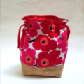 Drawstring bag with bold poppy print and faux cork reinforcing bottom section.