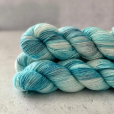 Tonal yarn from white to swimming pool blue.