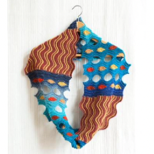 Cowl split into four sections. Two have a wavy pattern in two warm colors. The other two have a wild, swiss cheese pattern in cool bright colors, where some of the cheese holes are filled with shortrows of contrasting colors.