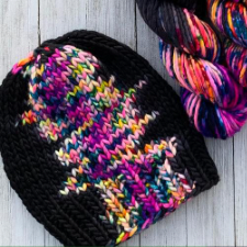 Hat made with dark and bright variegated yarn that makes all the bright colors pool in one section.