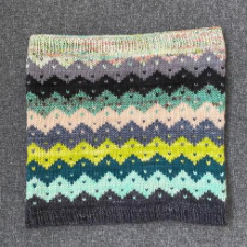 Colorwork cowl with zigzags in different colors. Each zigzag peak and valley is punctuated with a dot.