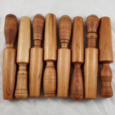 Several wooden yarn winders with various kinds of decorative woodwork on the handles.