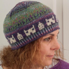 Intricate geometric colorwork tam-style beanie with buildings motif around the brim.