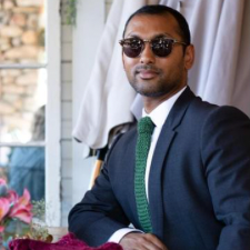 Businessman wearing crocheted necktie, suit and sunglasses. Tie has hidden elastic band to save tying the tie.