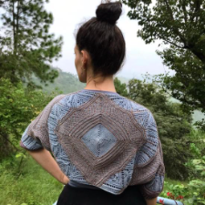 Center-out knitted design in two colors with lace sections.