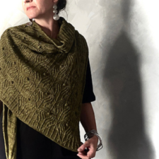 Triangular shawl with raised pattern that looks a bit like circuit board circuits.