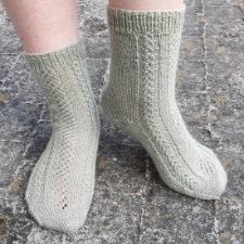 Socks with tiny cables down the sides and an openwork panel down the top.