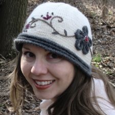 Cloche hat with I-cord flower and embroidered leaves.