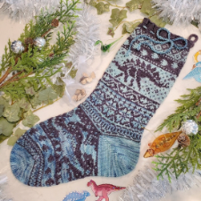 Colorwork stocking with several kinds of dinosaurs, most prominently a stegosaurus and allosaur.