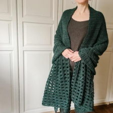 Long rectangular shawl in forest green with solid back and about 15 inches of openwork at each end.