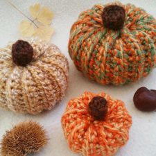 Crocheted pumpkins in three sizes with contrasting stems.