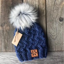 Cabled beanie with ribbed edge and large pom pom.