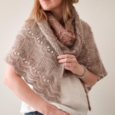 Asymmetrical lace and textured shawl worked sideways from tip with irregular side increases along its left edge. It has alternating sections knit in light fingering weight wool and mohair held together and single mohair strand held alone.