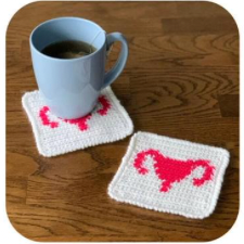 Crocheted colorwork coasters with the outline of a uterus and Fallopian tubes.