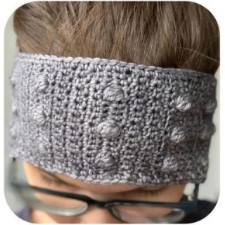 Wide earwarmer or headband with a few rows of bobbles.