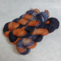 Dark to light variegated yarn in Halloween colors of pumpkin, violet and black.