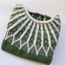 Roll-neck knitted sweater with contrasting cables and threads worked through the knitting.