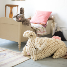 Two rabbit toys, one the size of a five-year-old child, the other the size of a large house cat. Bunnies are floppy and have floppy ears, too.