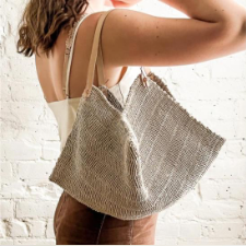 Woven bag with leather strap in natural linen.