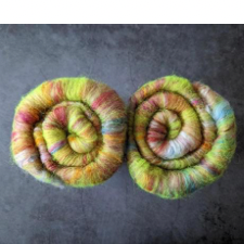 Ends of two rolled up batts. Colors are spring greens, sky blues and earth rust tones.
