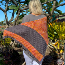 Triangular shawl begins at the small point and increases sideways toward the wide border. Pattern is stripes of slipped stitches with simple flowing cables.