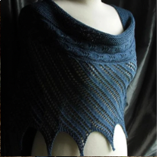 Simple diagonal lace shawl blocked to points, with textured band across top.