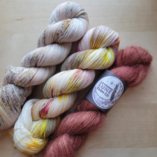 Two skeins of delicately variegated yarn and one skein of deep rose mohair.