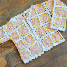 Granny square style button up cardigan. Each square features a lemon slice with pink fruit and a yellow rind.